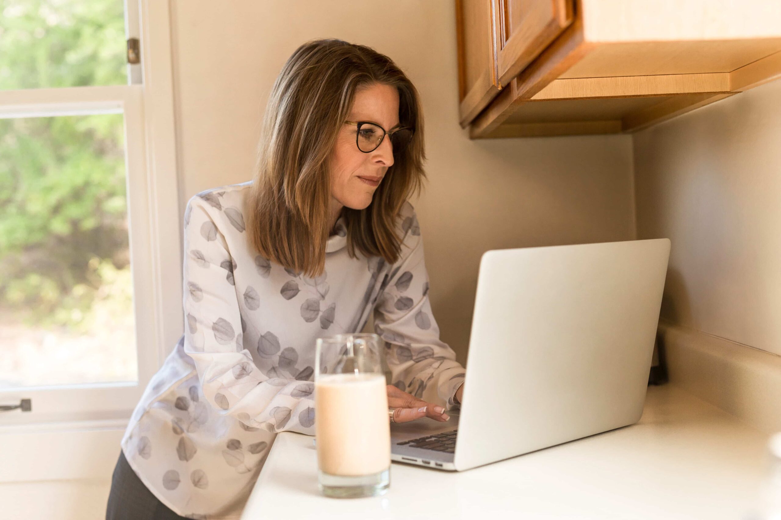 Kobieta siedząca w domu przed laptopem.
